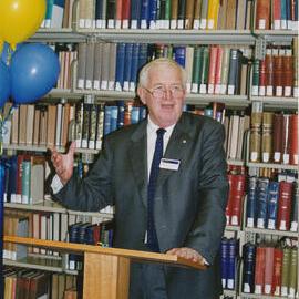 60538P - Vice Chancellor Professor Alan Robson - opening extensions / refurbishment Reid Library - standing at lectern in front of book shelves - balloons at left